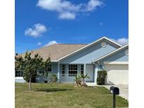 Charming single-story home with a well-maintained lawn, neutral toned roof, and light-blue siding at 1708 Blue Lake Cir, Punta Gorda, FL 33983