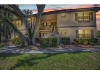 Condo exterior with lush landscaping, mature trees, and a serene setting at sunset at 19505 Quesada Ave # Tt101, Port Charlotte, FL 33948