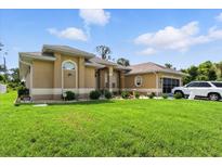 Beautiful single-story home featuring mature landscaping, an attached garage, and manicured lawn at 2329 Como St, Port Charlotte, FL 33948