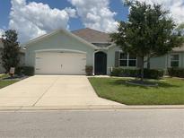 Inviting single-story home featuring a well-manicured lawn, two-car garage, and charming curb appeal at 25228 E Lenox Cir, Punta Gorda, FL 33950