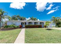 Charming single-story home with a well-manicured lawn and vibrant red flowering shrubs at 330 Weber Ter, Port Charlotte, FL 33952