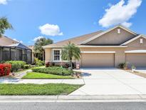 Charming single-story home with a well-manicured lawn, lush landscaping, and a two-car garage at 4180 Lenox Blvd, Venice, FL 34293
