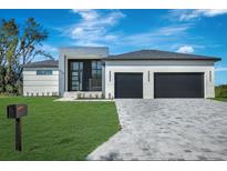 Stunning modern home with a two-car garage, clean lines, and beautiful stone driveway at 44 Sunflower Dr, Placida, FL 33946