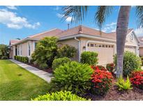 Beautiful home exterior with lush landscaping, a tile roof, and an attached two-car garage at 4567 Whispering Oaks Dr, North Port, FL 34287