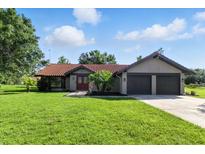 Charming single-story home featuring a well-manicured lawn and a two-car garage at 5052 Kingsley Rd, North Port, FL 34287