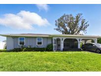 Charming single story home with a well-manicured lawn and covered parking at 6196 Mayberry Ave, North Port, FL 34287