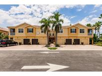 Inviting townhome complex with garages, manicured landscaping, and palm trees creating a desirable curb appeal at 8098 Moonstone Dr # 17-203, Sarasota, FL 34233