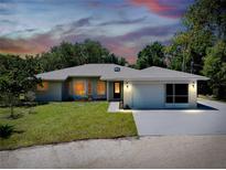 Charming single-story home with a well-maintained lawn and attached garage at 875 Bayshore Dr, Englewood, FL 34223