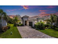 Charming single-Gathering home featuring a paver driveway, well-maintained landscaping, and a tile roof at 14684 Cherry Blossom Way, Punta Gorda, FL 33955
