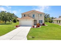Charming two-story home features a well-manicured lawn and attached two-car garage at 200 Valdiva St, Punta Gorda, FL 33983
