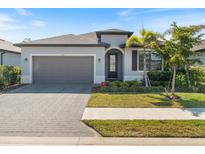 Charming single-story home featuring a paved driveway, two-car garage, and manicured landscaping at 2161 Gardenia Ave, Port Charlotte, FL 33953