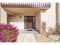 Inviting front entrance features a brown front door, blooming bougainvillea and decorative stone landscaping at 311 Garvin St # 301B, Punta Gorda, FL 33950