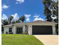 Charming single-story home featuring a well-manicured lawn and a two-car garage at 3532 Richardson St, North Port, FL 34288