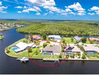 Expansive waterfront property boasts a private pool, dock, and stunning views of the surrounding waterways and lush greenery at 4142 Reif Ct, Port Charlotte, FL 33981