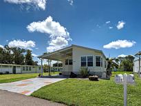 Charming single-story home featuring a covered carport and well-maintained landscaping and quaint mailbox at 6562 Hikina Dr, North Port, FL 34287