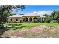 Charming single-story home with a metal roof and lush landscaping at 6594 Buckboard St, North Port, FL 34291