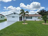 Charming single-story home with manicured lawn and palm trees adding a tropical touch at 724 Hartford Nw Dr, Port Charlotte, FL 33952