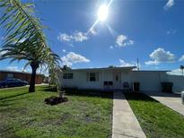 Charming single-story home with a well-maintained lawn, complemented by a beautiful palm tree at 2336 Picnic St, Port Charlotte, FL 33952