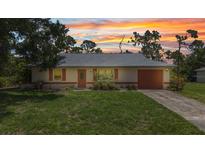 Charming single-story home with a well-maintained lawn and a cozy curb appeal at sunset at 1242 Orlando Blvd, Port Charlotte, FL 33952
