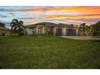 Beautiful single-story home featuring a well-manicured lawn, neutral tones, and a spacious three-car garage at 25062 Palisade Rd, Punta Gorda, FL 33983