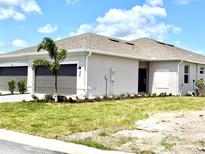 Charming single-story home features a well-manicured lawn, two-car garage, and neutral stucco exterior at 8706 Seasalt Loop, Englewood, FL 34224