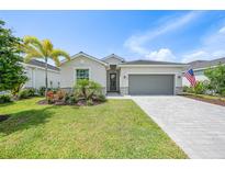 Charming single-story home featuring a paver driveway, two-car garage, and meticulously maintained landscaping at 11383 Burgundy Dr, Venice, FL 34293