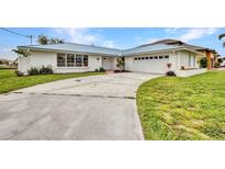 Charming home boasts a metal roof, white paint, and well-maintained lawn at 114 Sinclair Se St, Port Charlotte, FL 33952