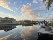 Beautiful waterfront homes with private docks reflecting the sunny skies and scattered clouds at 1335 Mineo Dr # G, Punta Gorda, FL 33950