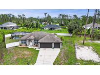 Charming single-story home featuring a spacious driveway, three-car garage, and beautiful landscaping at 1546 Gourmet Rd, North Port, FL 34288