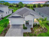 Beautiful single-story home with a two-car garage, brick paved driveway, and manicured landscaping at 16336 Preservation Blvd, Punta Gorda, FL 33982
