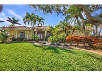 Beautiful home featuring a well-manicured lawn, vibrant landscaping, and a charming red tile roof at 17188 Cape Horn Blvd, Punta Gorda, FL 33955