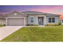 Charming one-story home with blue shutters, manicured lawn, and inviting curb appeal at 17200 Gulfspray Cir, Port Charlotte, FL 33948