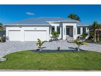 Beautiful home featuring a three-car garage, pristine landscaping, and a modern architectural style at 245 Lido Dr, Punta Gorda, FL 33950