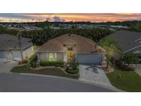 Beautiful home with a well-manicured lawn and landscaping, complemented by palm trees and a warm, inviting sunset at 24504 Buckingham Way, Punta Gorda, FL 33980