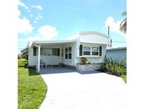 Charming single-story home with a covered porch and well-maintained landscaping at 326 Trailorama Dr, North Port, FL 34287