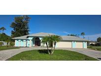 Charming, light blue single-story home with manicured lawn and paver driveway for curb appeal at 39 Norman St, Port Charlotte, FL 33954