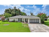 Charming single-story home featuring a well-maintained lawn, mature landscaping, and a two-car garage at 475 Whippoorwill Dr, Venice, FL 34293