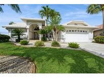 Charming single-story home with a well-manicured lawn and lush tropical landscaping at 5048 San Massimo Dr, Punta Gorda, FL 33950