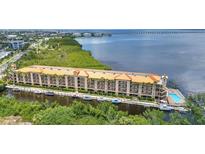 Expansive waterfront condo building with boat docks, pool, and lush green landscaping provides an ideal coastal lifestyle at 900 E Marion Ave # 1403, Punta Gorda, FL 33950