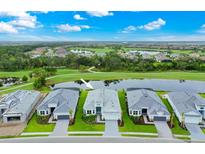 Stunning aerial view of a modern home with lush landscaping and a serene lake view at 14846 Contenta Loop, Bradenton, FL 34211