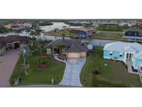 Waterfront home with landscaped yard, private dock, boat lift and decorative driveway at 8178 Arlewood Cir, Port Charlotte, FL 33981