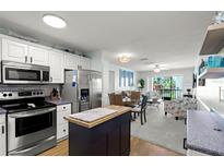 Open floor plan featuring a modern kitchen with stainless steel appliances and a cozy living area with a balcony at 915 Beach Rd # 215, Siesta Key, FL 34242