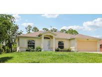 Charming single-story home featuring a manicured lawn, attached two car garage, and welcoming front entrance at 5260 Jessamine Ave, North Port, FL 34291