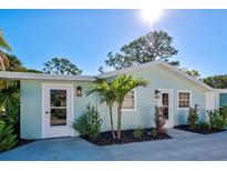 Charming light teal house with landscaping and a concrete walkway at 415 Yale St, Englewood, FL 34223