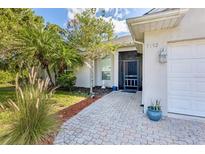 Charming home featuring a paved walkway, lush landscaping, and a welcoming screened entrance at 7192 N Paragon Rd, North Port, FL 34291