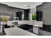 Modern kitchen with black cabinets and white countertops at 118 Green Pine Park, Rotonda West, FL 33947