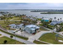 Stunning waterfront home featuring a modern design, lush landscaping, and a private pond with dock at 342 Green Dolphin Dr, Placida, FL 33946
