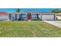 Single-story home with gray exterior and red door at 2341 Rio De Janeiro Ave, Punta Gorda, FL 33983