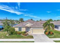 Charming single-story home with well-manicured lawn, mature trees, and a two-car garage at 584 Gadsen St, Englewood, FL 34223
