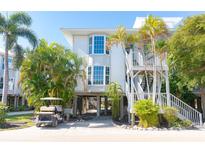 Elevated home exterior with golf cart and landscaping at 7450 Palm Island Dr # 3411, Placida, FL 33946